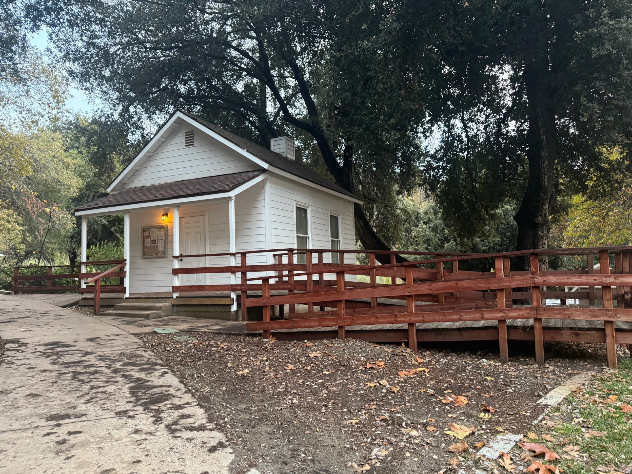 A small white house with a ramp leading up to the front porch.