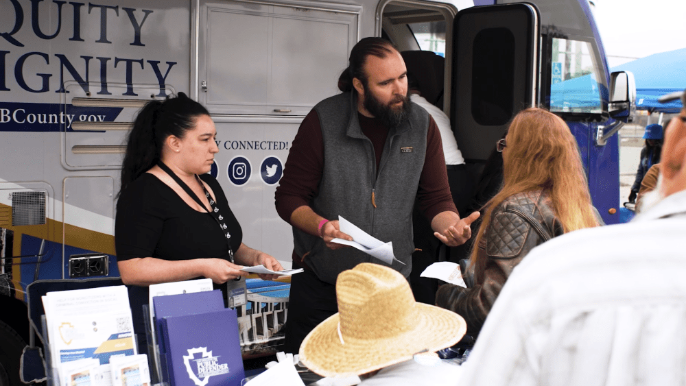 Public Defender staff assist community members with paperwork outside the Mobile Defense Unit at an outreach event.