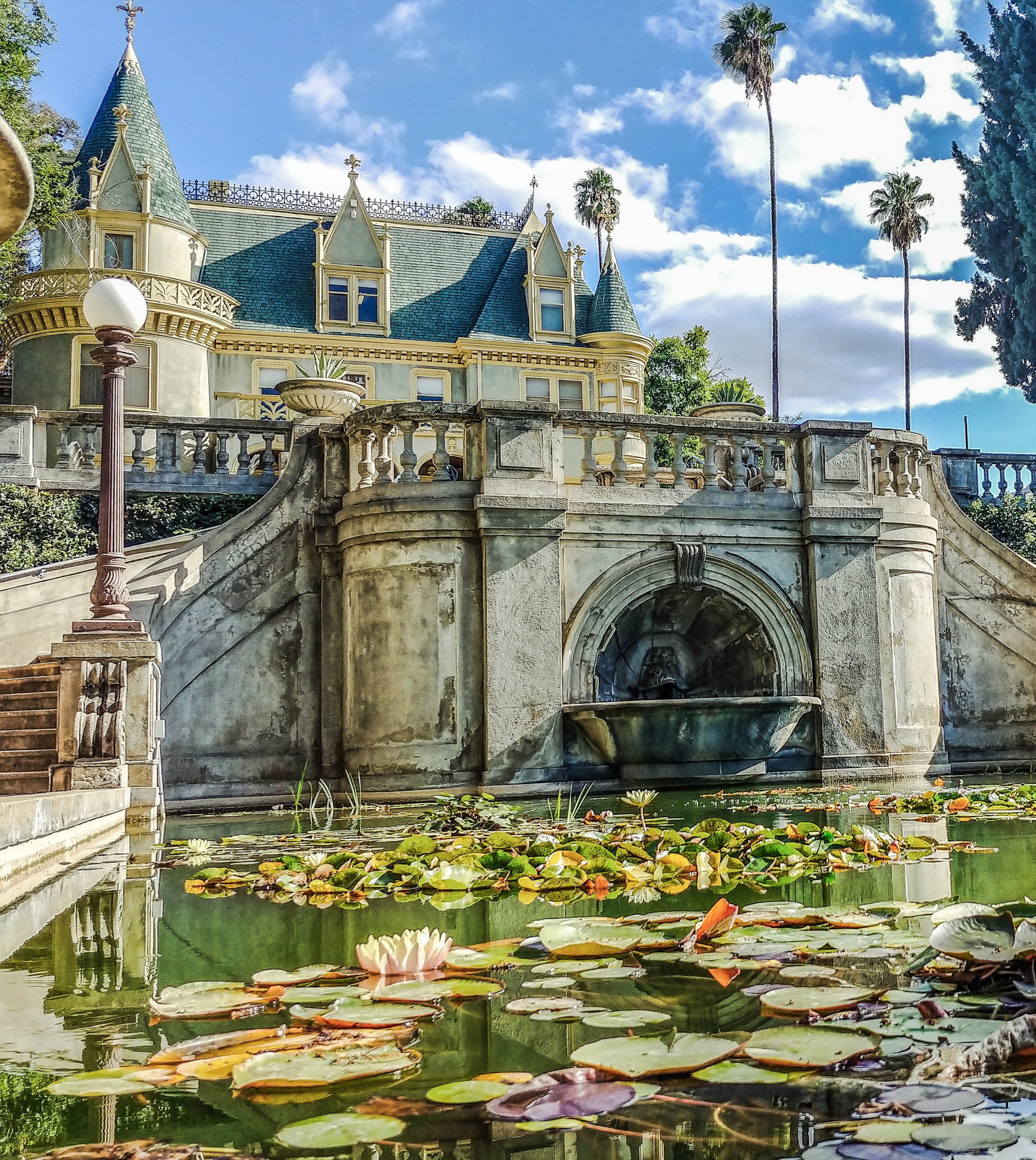 View of the Kimberly Crest House and Gardens with a pond featuring lily pads.
