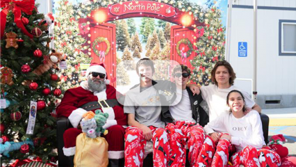 Group of community members posing with Santa at the Home for the Pawlidays event at a county animal shelter.