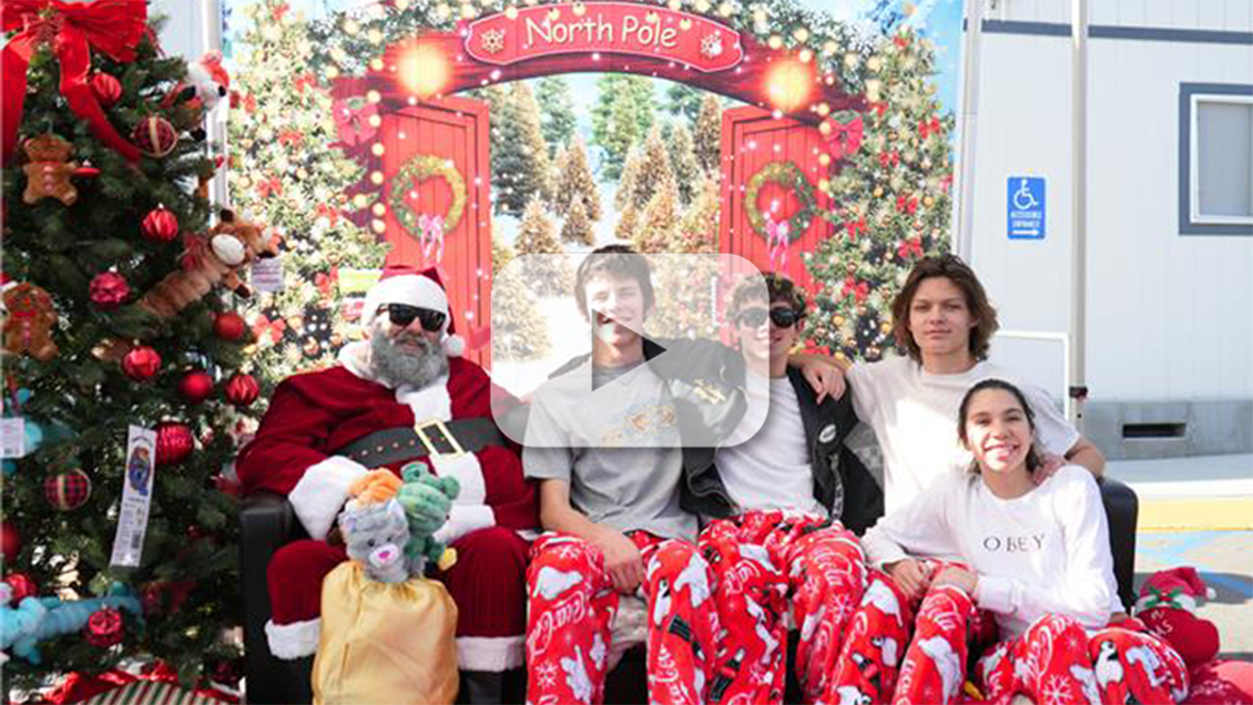 Group of community members posing with Santa at the Home for the Pawlidays event at a county animal shelter.