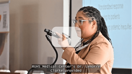 Dr. Lenorre Clarke speaks at a podium with a slide behind her and closed captions, “RUHS Medical Center’s Dr. Lenorre Clarke provided.”