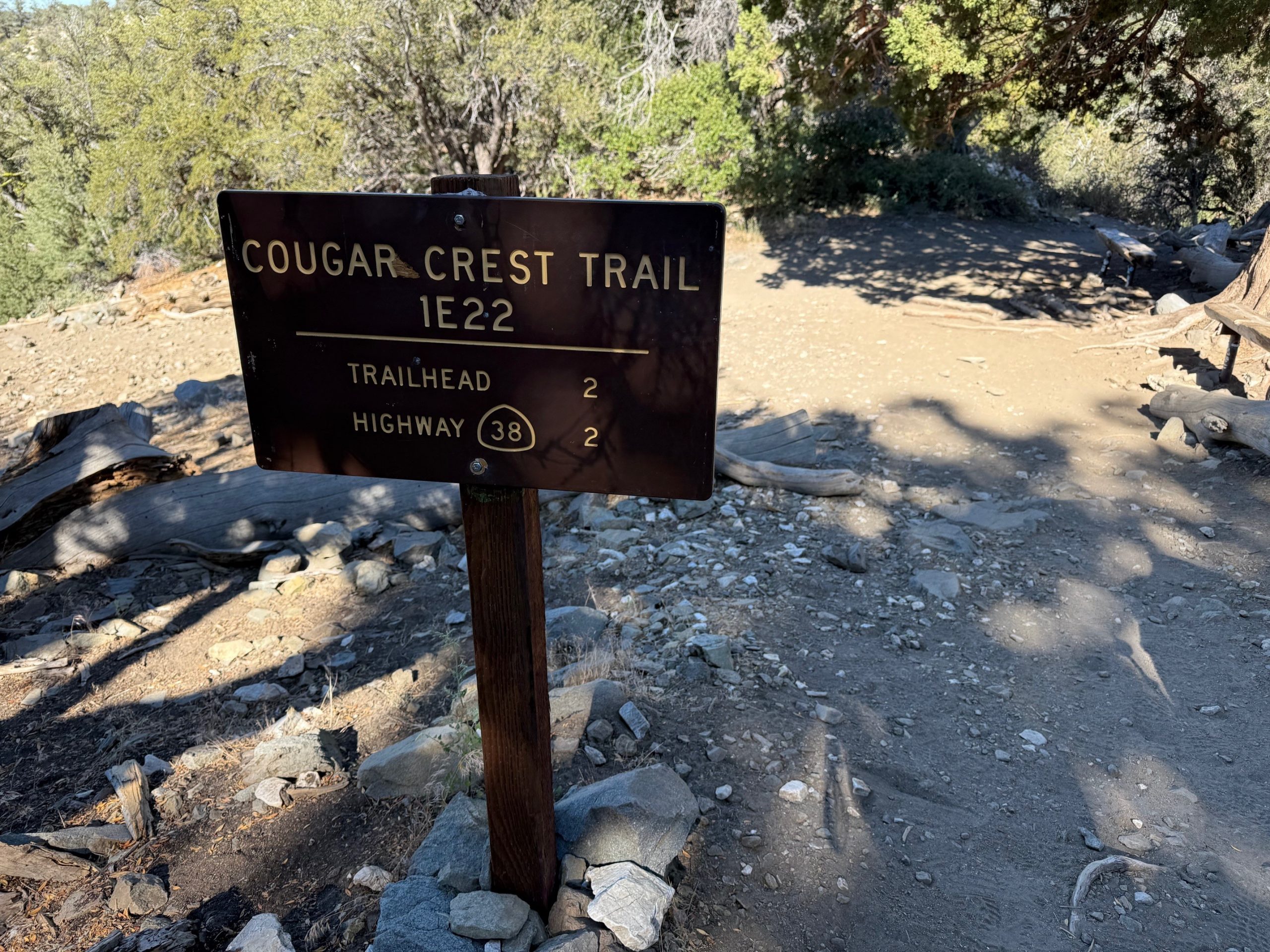 Cougar Crest Trail signage with foliage in the background.
