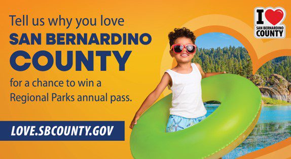 A child with a float ring surrounded by a lake with text that says, "Tell us why you love San Bernardino County for a chance to win a Regional Parks annual pass." Also visible is love.sbcounty.gov.
