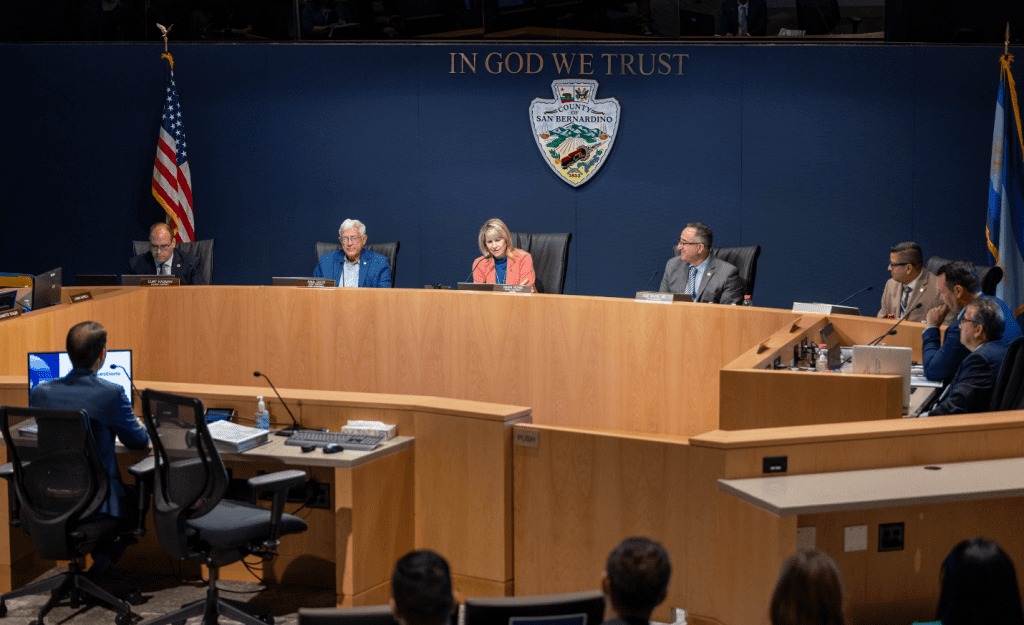 San Bernardino County Board of Supervisors seated at a dais with other county officials seated around the dais.