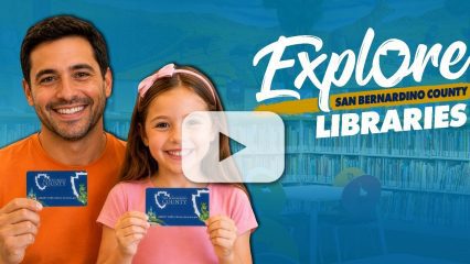 Father and daughter smile and hold library cards with a video play button overlay. An “Explore San Bernardino County” services logo appears in the corner.
