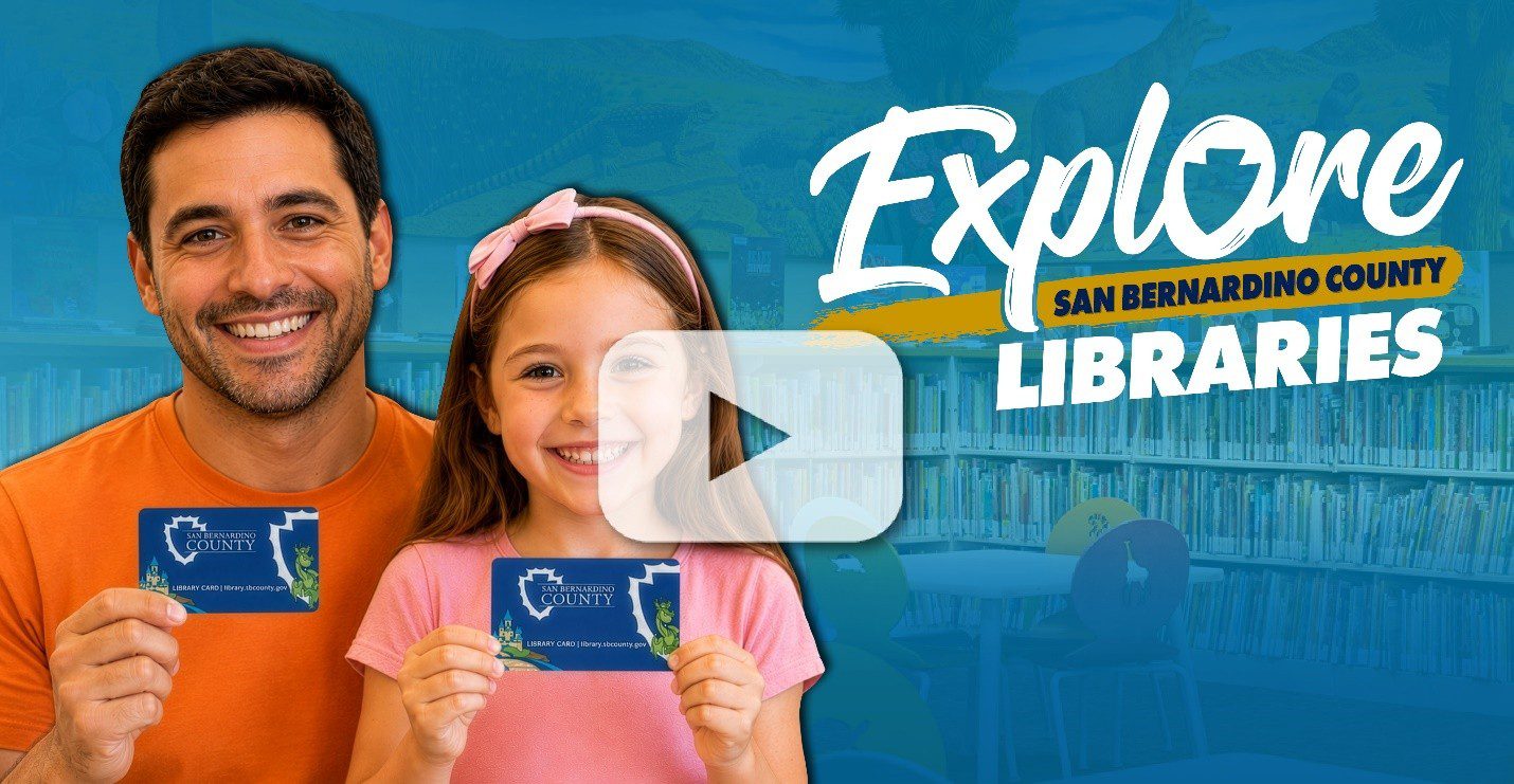 Father and daughter smile and hold library cards with a video play button overlay. An “Explore San Bernardino County” services logo appears in the corner.