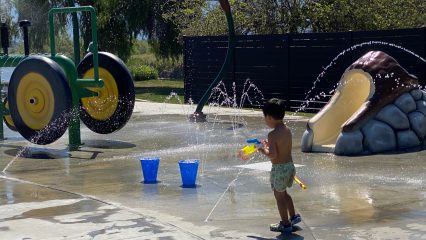 A young boy plays in a splash pad.