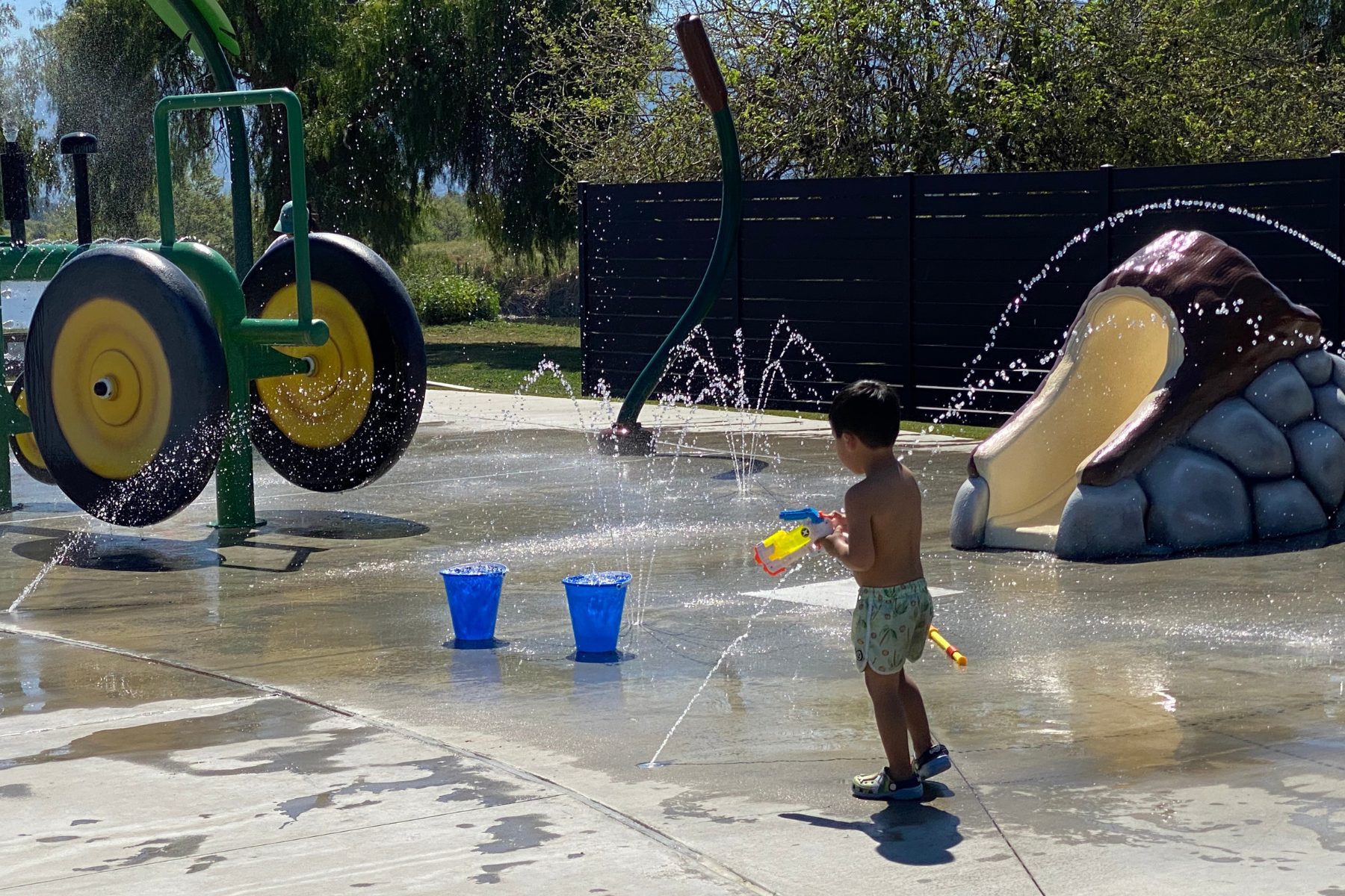A young boy plays in a splash pad.