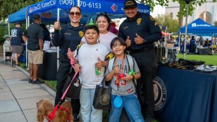 Two SBC Probation officers pose with a family at a community outreach booth.