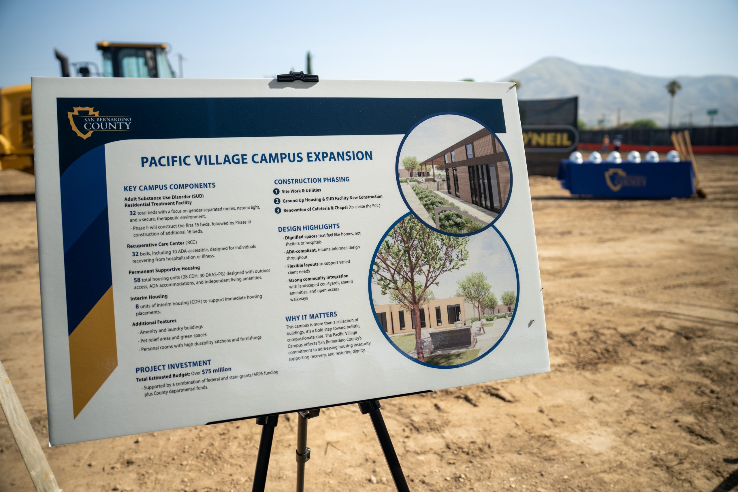 A sign labeled "Pacific Village Campus Expansion" at a construction site that includes campus components, a project investment summary, phasing, design highlights and why it matters.