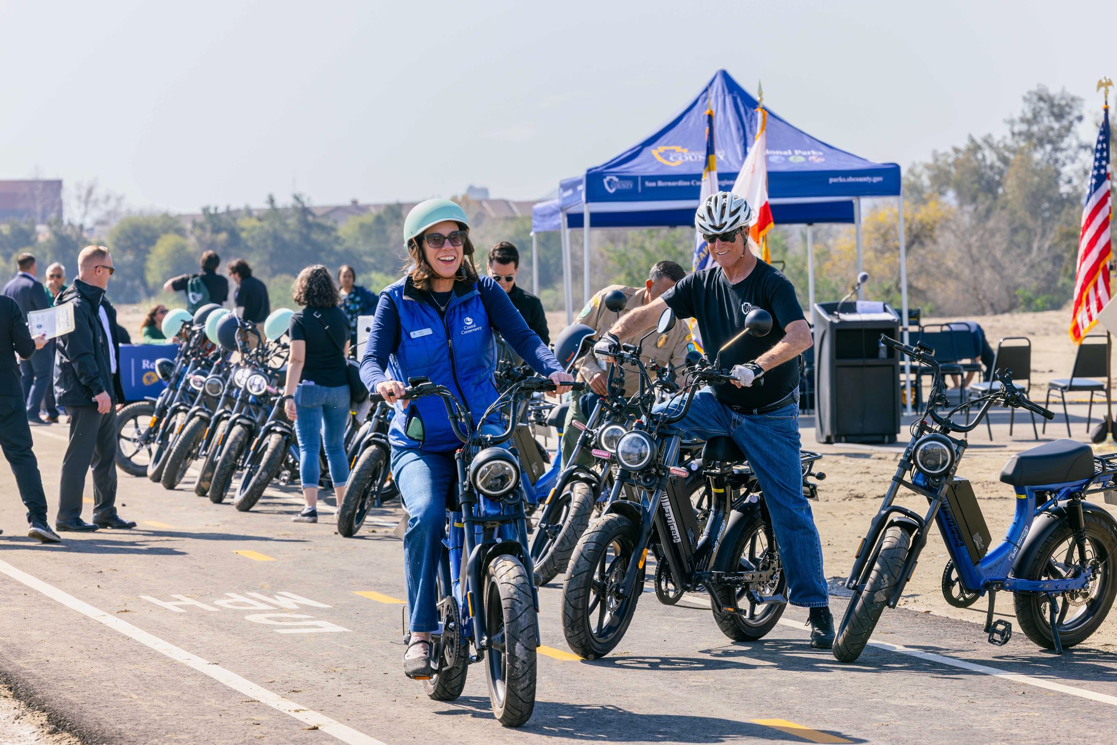 A woman and man are seen riding e-bikes on the Santa ana River Trail in San Bernardino.