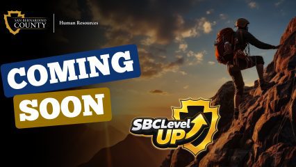 San Bernardino County Human Resources graphic announcing “Coming Soon” for SBC LevelUP with hiker climbing a mountain at sunset.