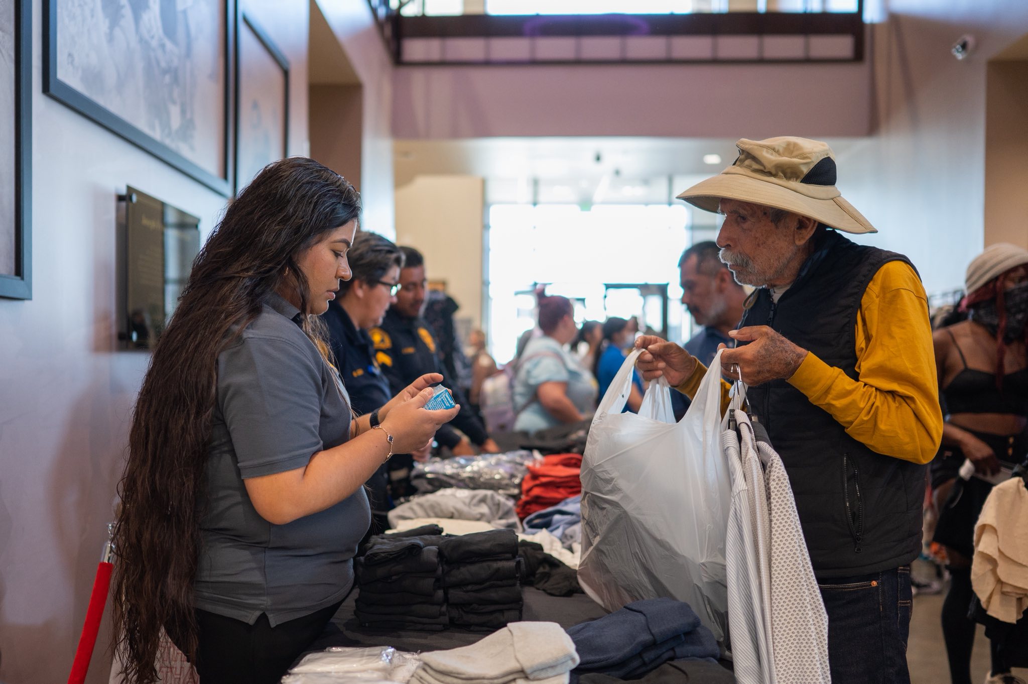 Community member receives clothing assistance from outreach staff at an indoor resource event.