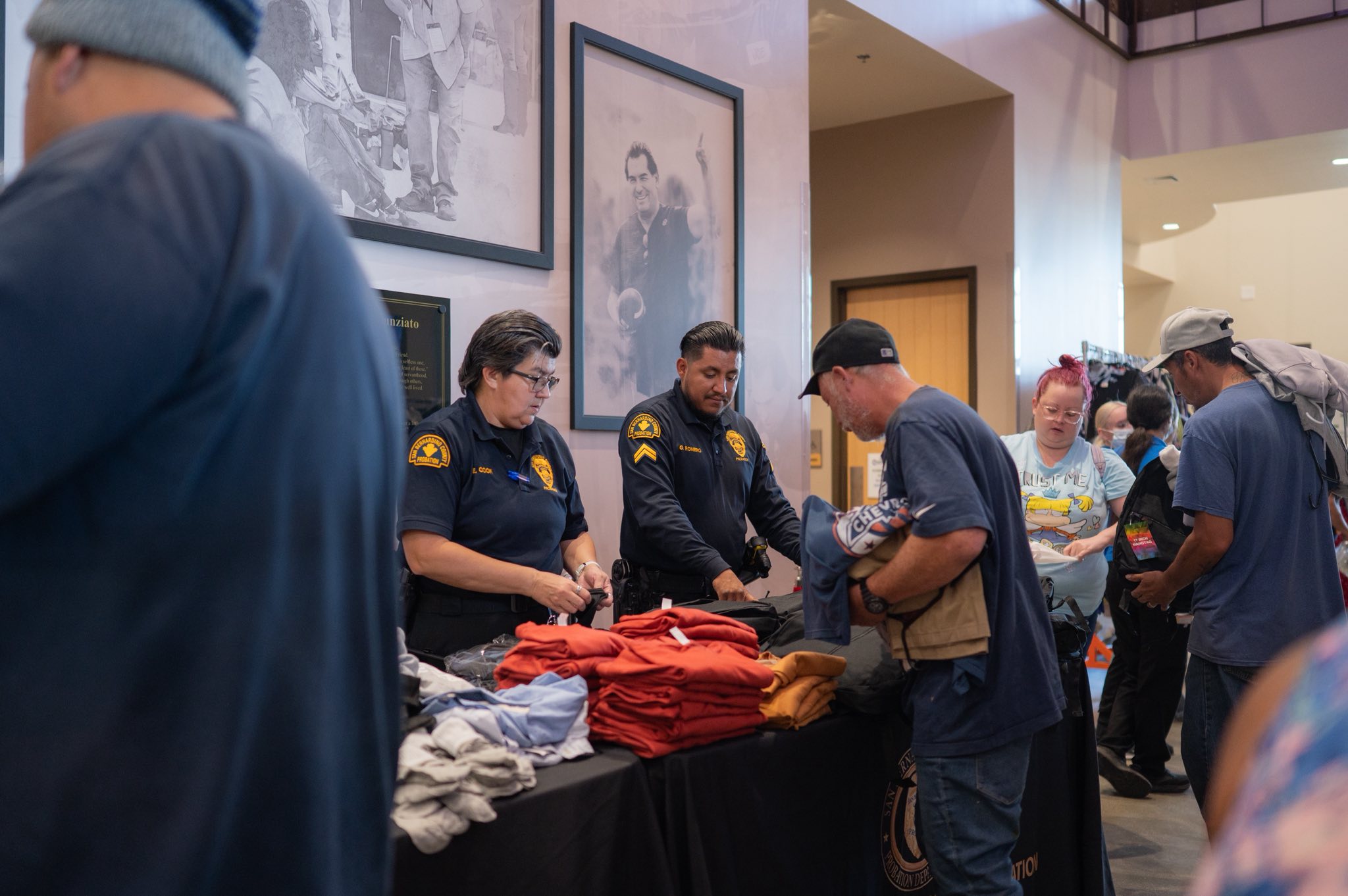 Probation staff assist community members selecting clothing at a resource distribution event.
