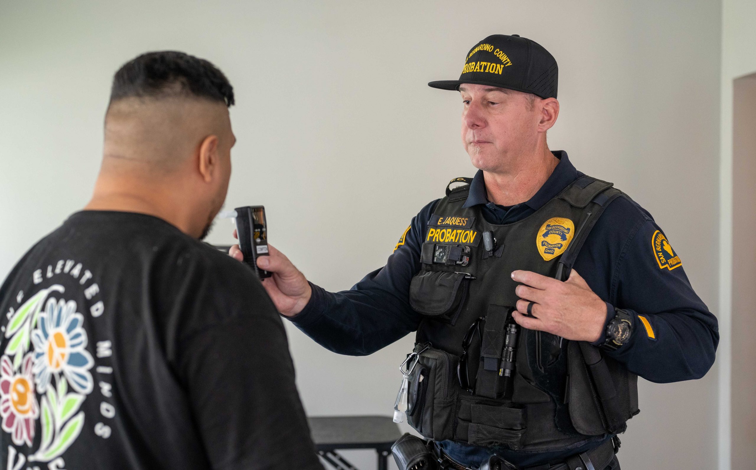 A probation officer conducting a preliminary alcohol screening on a probationer.