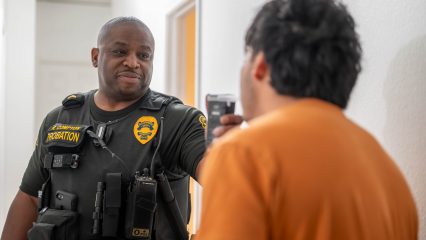 A probation officer conducting a preliminary alcohol screening on a probationer.