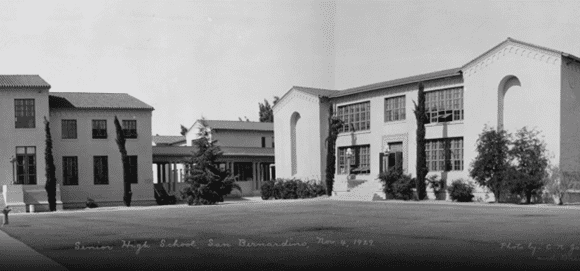 Black and white photograph of San Bernardino High School taken on November 4, 1929, showing several large buildings surrounded by trees and grass.