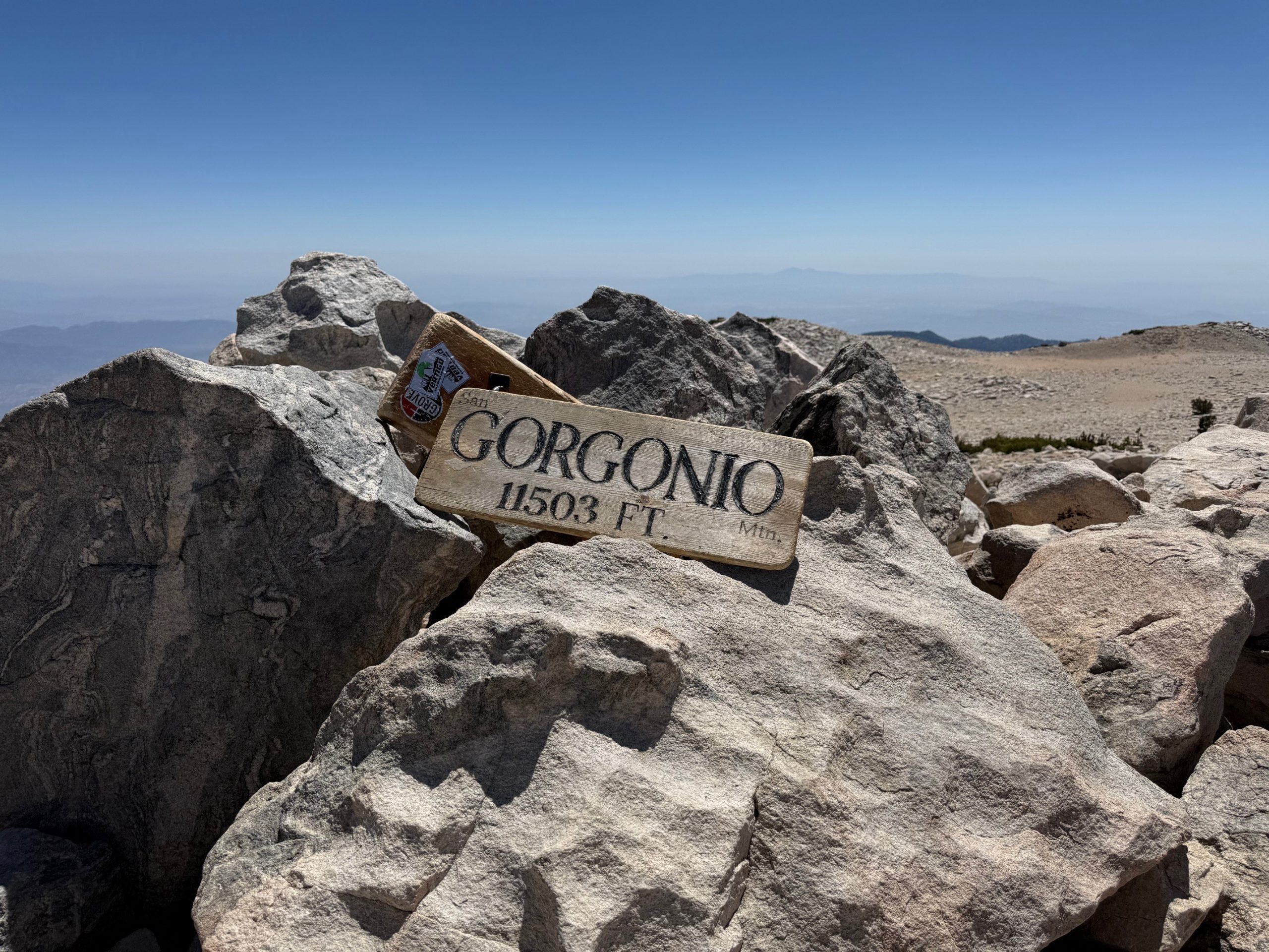 A wooden sign that says "Gorgonio 11,503 feet" on a pile of rocks.