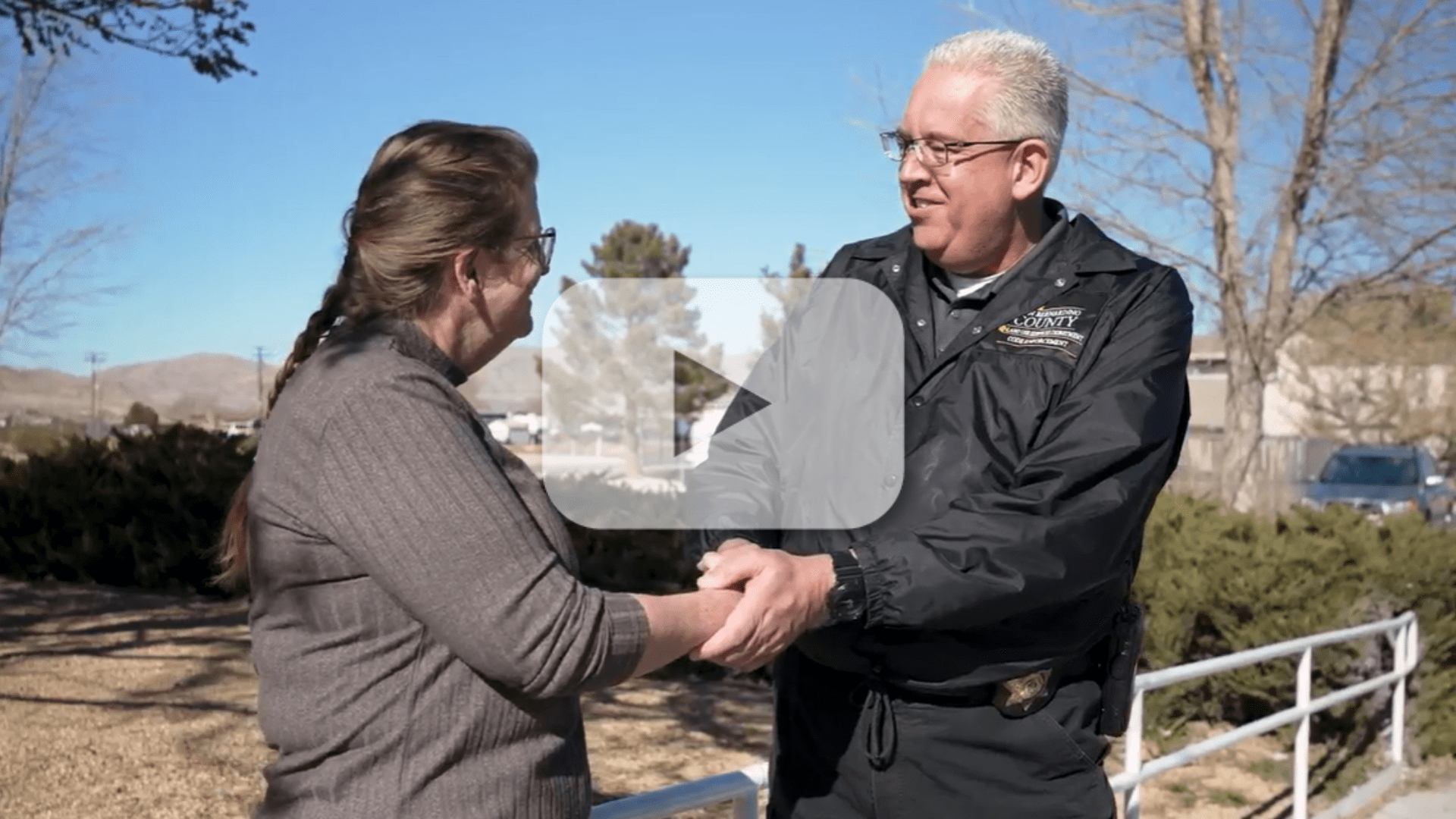 A constructive discussion between a woman and a San Bernardino County Code Enforcement Officer resolving her case. The image has a video play button overlay, indicating a video.