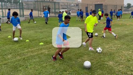 Youth practice soccer drills on a grassy field during the 16th Annual Sports Faire hosted by Children and Family Services.