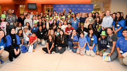 Group of ARMC staff and children pose together during Take Your Child to Work Day, celebrating a day of learning and hands-on hospital tours.