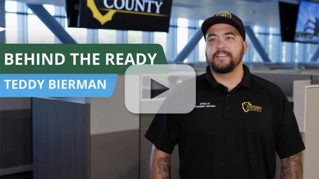 Teddy Bierman of San Bernardino County OES in a “Behind the Ready” video thumbnail with a play button.