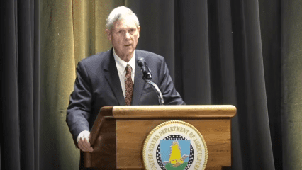 United States Secretary of Agriculture Tom Vilsack stands at a podium.