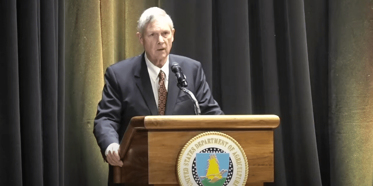 United States Secretary of Agriculture Tom Vilsack stands at a podium.