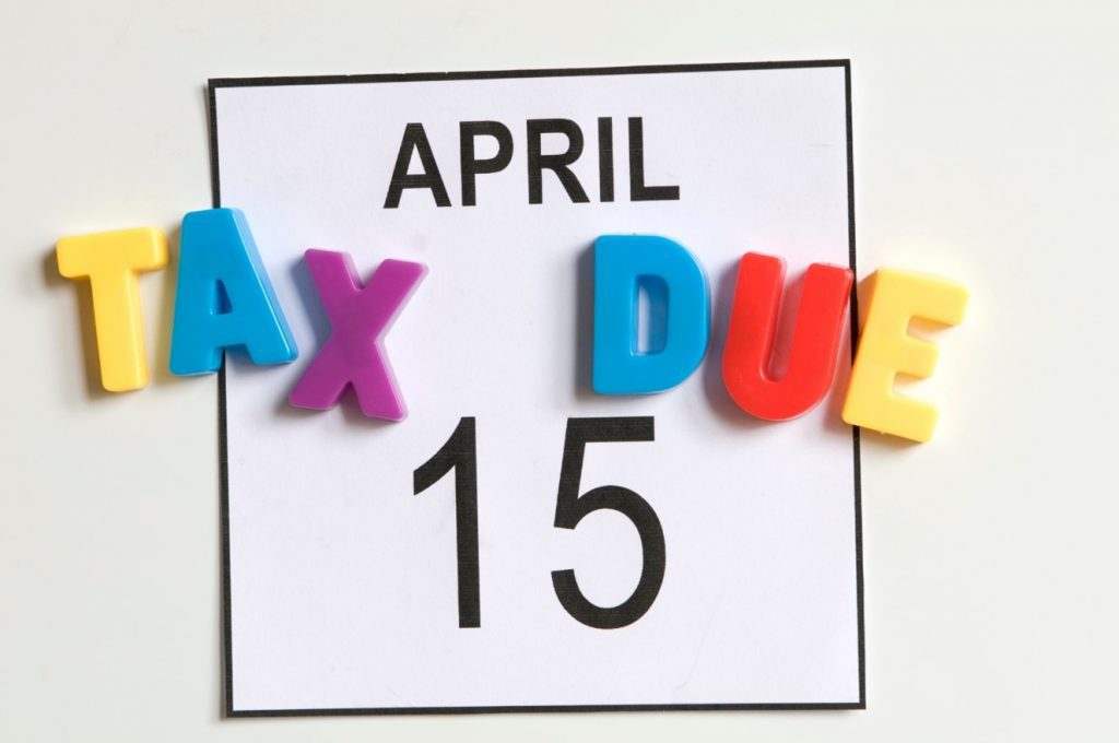 Calendar page with colorful letters spelling TAX DUE over date. Text reads: APRIL TAX DUE 15.