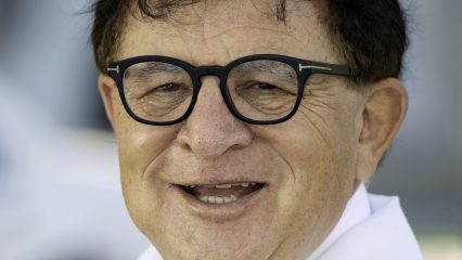 A male doctor wearing a white laboratory coat with the Arrowhead Regional Medical Center logo smiles at the camera.