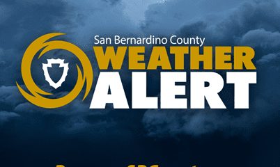 San Bernardino County Weather Alert with county shield in gold hurricane symbol on stormy cloud background. Text: Prepare.SBCounty.gov.