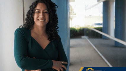 Woman standing outside near a pillar and window, with shrubs in the background and the Child Support Services logo in a blue and gold box.