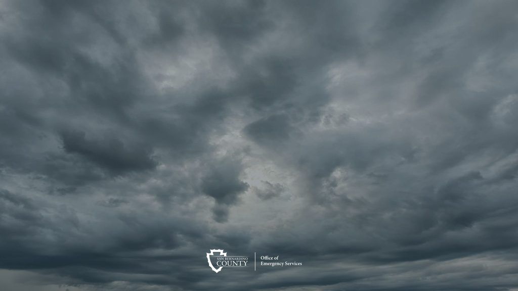 Dark storm clouds, with the San Bernardino County Office of Emergency Services logo.