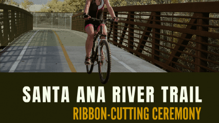 A woman seen riding a bike on a bridge surrounded by trees with the words Santa Ana River Trail Ribbon-Cutting Ceremony. Regional Parks logo, sbcounty.gov.