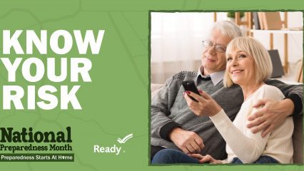 An older male with his arm around an older female, sitting with a television remote in hand. Text reads Know Your Risk. National Preparedness Month: Preparedness Starts at Home.