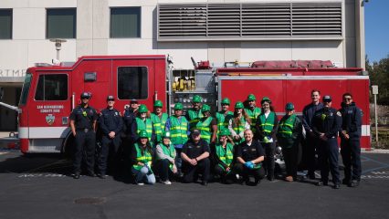 Group of emergency responders posing in front of a fire truck.